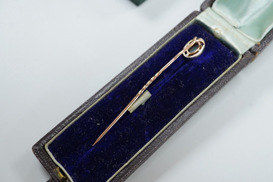 A cased late Victorian 9ct and single stone amethyst set bar brooch, 45mm, a cased yellow metal and single stone white opal set stick pin and a modern 18ct white gold, ruby and diamond cluster ring, size L/M.